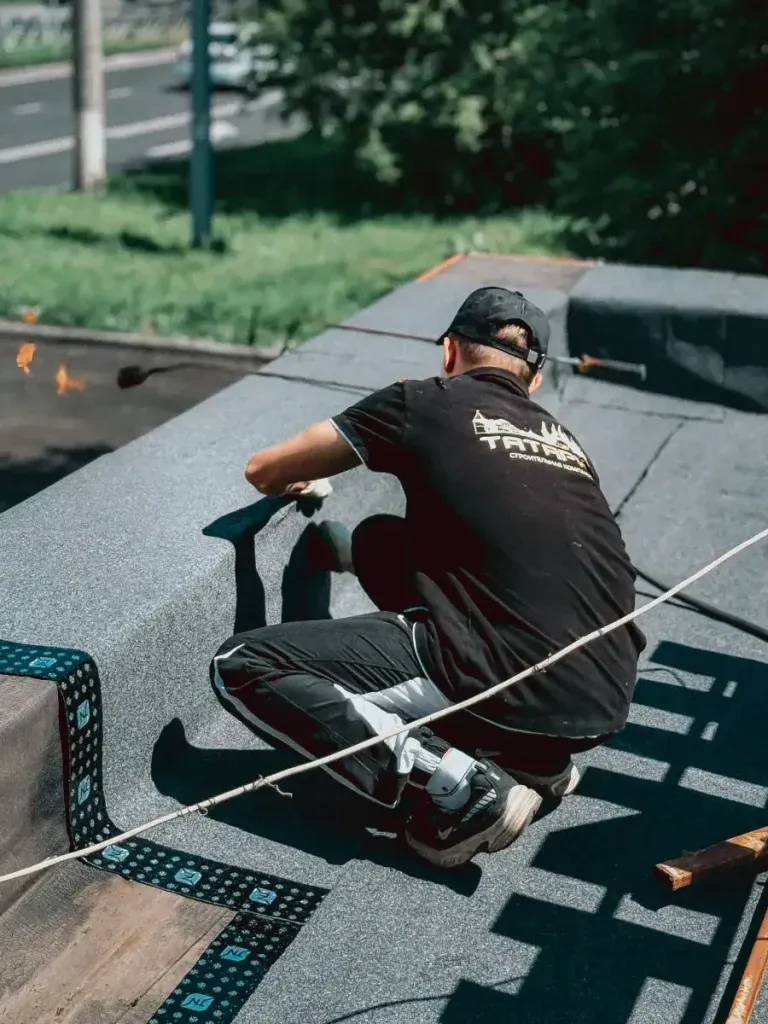 Roofer working on a flat roof in daylight