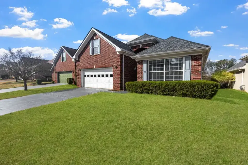 Red brick suburban home with a durable shingle roof