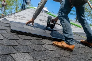 Close up of a roofer installing architectural shingles on a residential roof