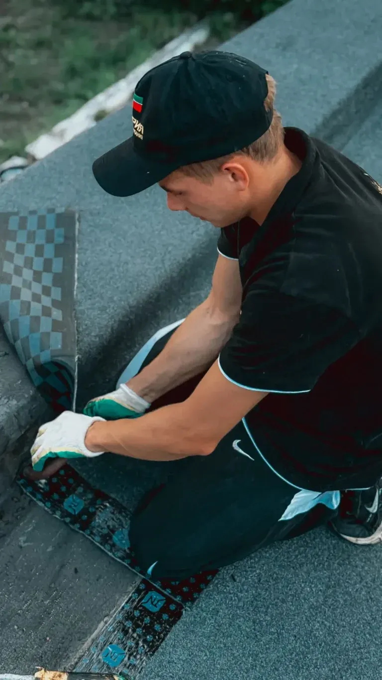 Roofer applying shingles during a roof installation