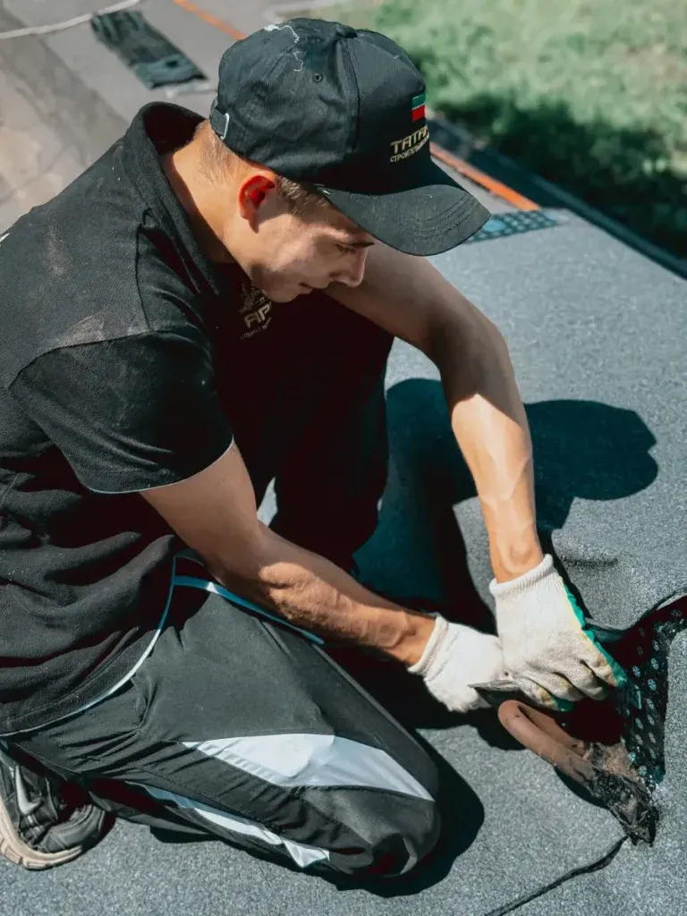 Roofer applying a TPO waterproof membrane on a commercial flat roof